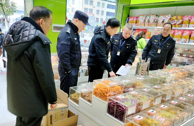 执法人员在超市进行食品抽样。
